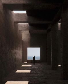 a person standing in an empty room with long shadows on the walls and flooring