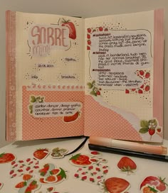 an open notebook with strawberry stickers on it