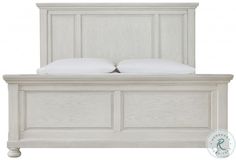 a white wooden bed with two pillows on it's headboard and foot board