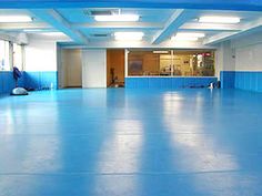 an empty room with blue walls and flooring in the middle is seen from across the room