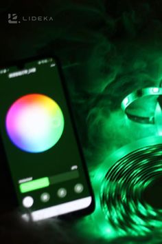 a cell phone sitting on top of a table next to a green and red light