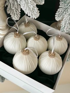 six white christmas ornaments in a box