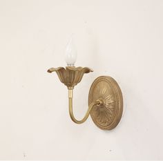 an antique brass wall light with a white background