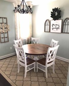 a dining room table and chairs in front of a window