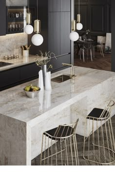 a modern kitchen with marble counter tops and gold accents on the cabinets, along with brass stools