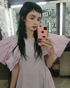 a woman taking a selfie in front of a mirror wearing a pink dress and holding a cell phone