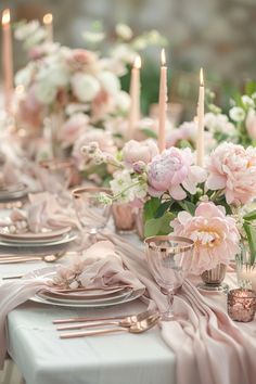 the table is set with pink flowers and candles