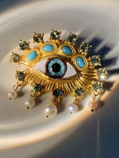 Capture the essence of vintage elegance with this Hemlock Pearl Embellihsed Eye Brooch. Boasting a timeless design with intricate details and exquisite craftsmanship, this brooch exudes class and sophistication. Wear it to add a subtle yet luxurious statement to any ensemble. Material: Alloy Timeless Luxury Brooch Jewelry, Designer Luxury Brooch, Vintage Luxury Statement Jewelry, Luxury Vintage Statement Jewelry, Luxury Gold Brooches With Intricate Design, Elegant Gold Enamel Pin For Party, Luxury Brooches With Intricate Design, Elegant Gold Baroque Brooch, Elegant Gold Baroque Brooches