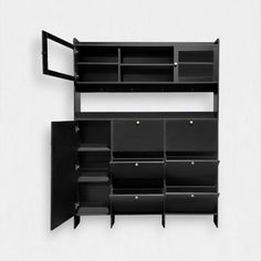 a black shelf with several bins and shelves on it's sides, against a white wall