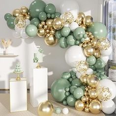 the balloon arch is decorated with gold, white and green balloons