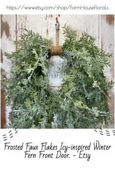 a wreath hanging on the side of a wooden door with text overlay that reads frosted fauxs icy - inspired winter fern front door - etsy