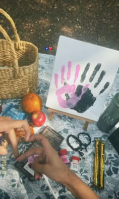 two people are making handprints with their hands on a table next to some fruit