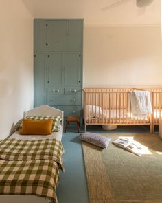 a bedroom with two beds and a green door