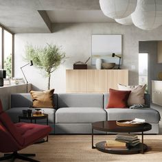 a living room filled with lots of furniture and pillows on top of a rug next to a coffee table