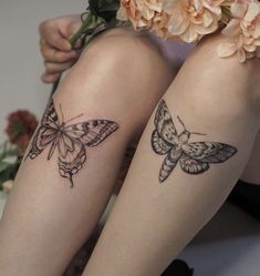 two butterflies tattoo on legs sitting next to each other with flowers in front of them