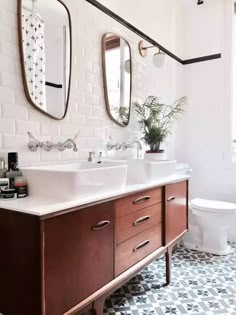 a bathroom with two sinks and mirrors above the sink is decorated in black and white tiles