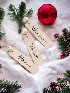 two wooden tags with the words thank you on them next to pine cones and christmas decorations