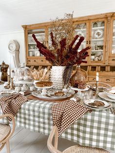 a dining room table is set with dishes and place settings for the holiday dinner party