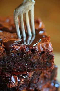 a fork is stuck into a piece of chocolate cake