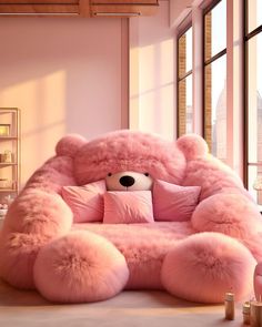 a large pink teddy bear sitting on top of a couch