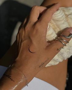 a close up of a person's arm with tattoos on her left hand holding a banana