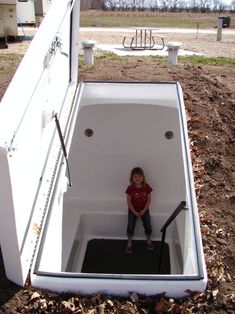 a little boy sitting in the back of a white boat