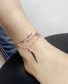 a woman's foot with a small tattoo on the side of her leg and a feather