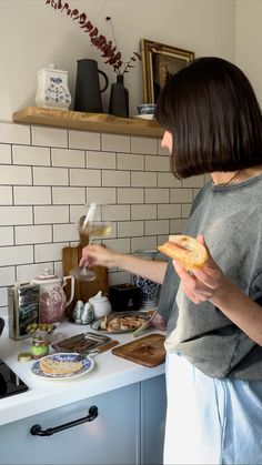 a woman standing in a kitchen preparing food