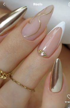 a woman's hand with some gold and white nails