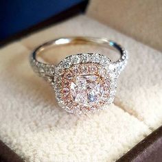 a diamond ring sitting on top of a white and brown velvet covered cushion in a box