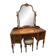 an antique dressing table with mirror and stool