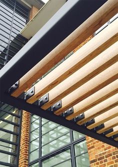 an outside view of a building with wooden slats on the side and glass windows