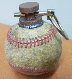 an old baseball ball with a metal clip on it's top is sitting on a table