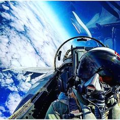 an air force pilot is in the cockpit of his fighter jet looking out into the clouds