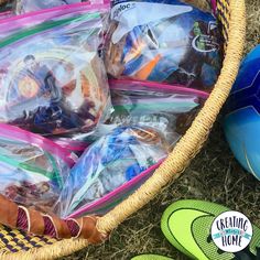 a basket filled with lots of toys next to some green and blue shoes on the ground