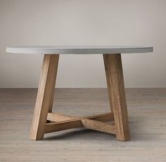 a white table sitting on top of a hard wood floor next to a gray wall