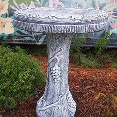 a bird bath sitting in front of a mural