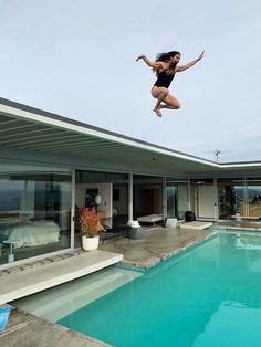 a woman jumping into the air from a swimming pool