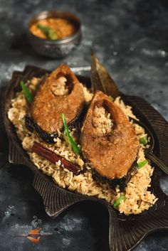 some kind of food that is on a plate with rice and other foods in the background