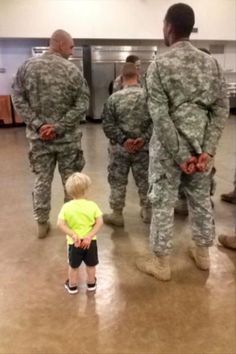 a little boy standing in front of soldiers