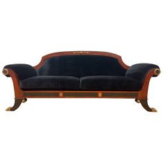 a black velvet and wood sofa with gold trim