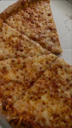 two slices of cheese pizza sitting on top of a white paper plate in a box