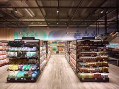 an empty grocery store filled with lots of food and drink bottles on display in the aisles