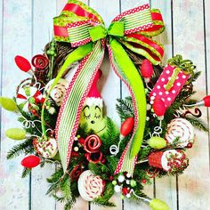 a christmas wreath with candy canes, candies and a grin face on it