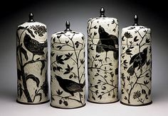 three vases with birds on them are lined up in front of the same one