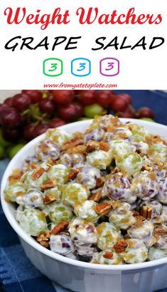 a white bowl filled with grapes salad next to some grapes and other fruit in the background