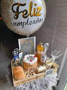 a table topped with cake and desserts on top of a wooden tray next to a balloon