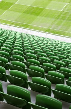 rows of green seats in front of an empty soccer field