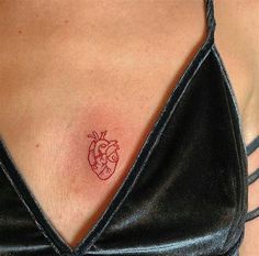 a woman with a heart tattoo on her chest