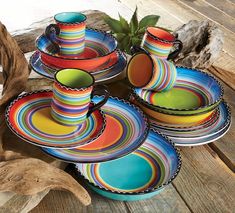 colorful plates and cups are stacked on top of each other